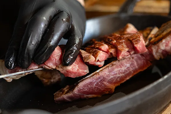 焼き上げた塊肉をカットするシェフの手元